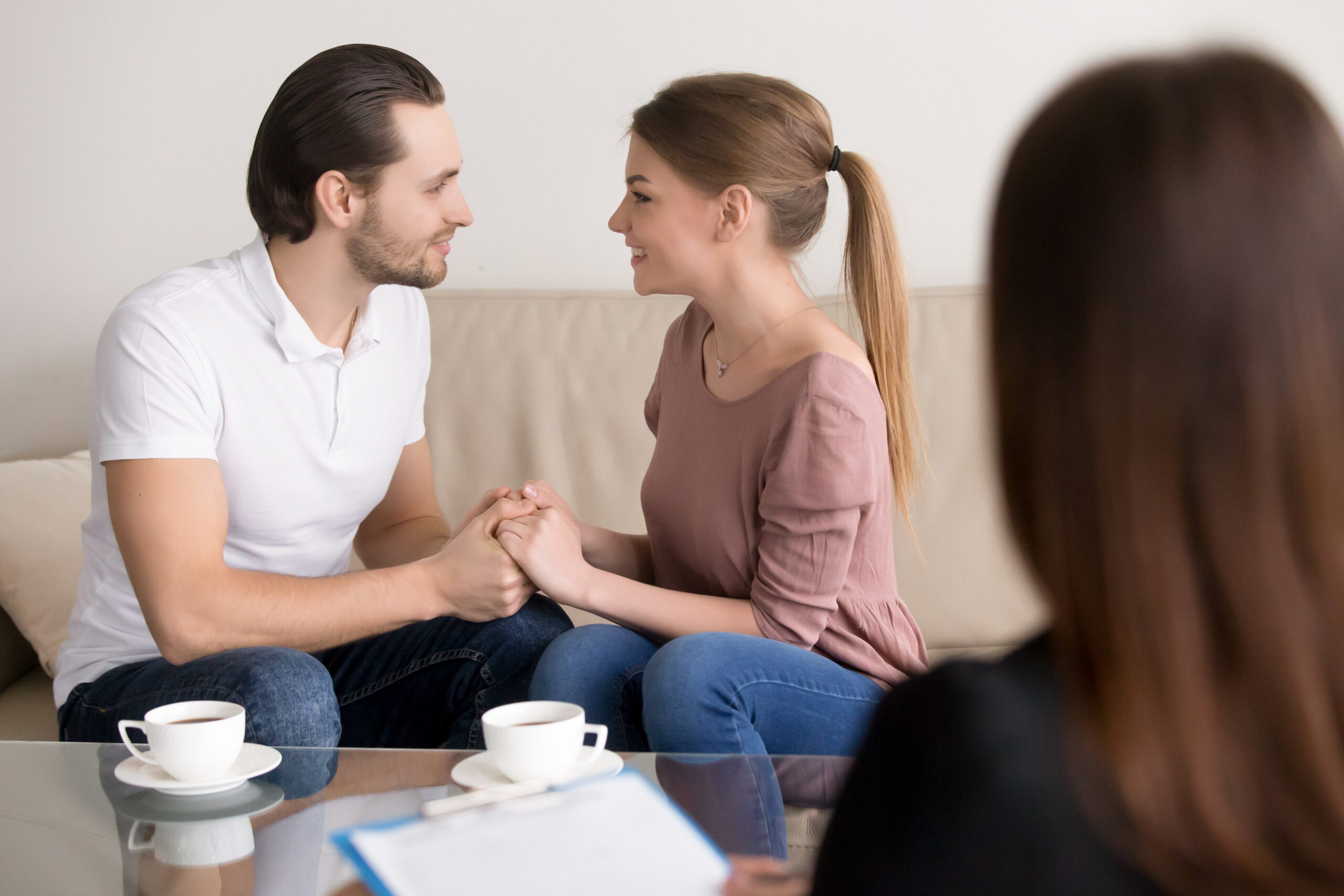 happy smiling young couple holding hands, consulting psychologis