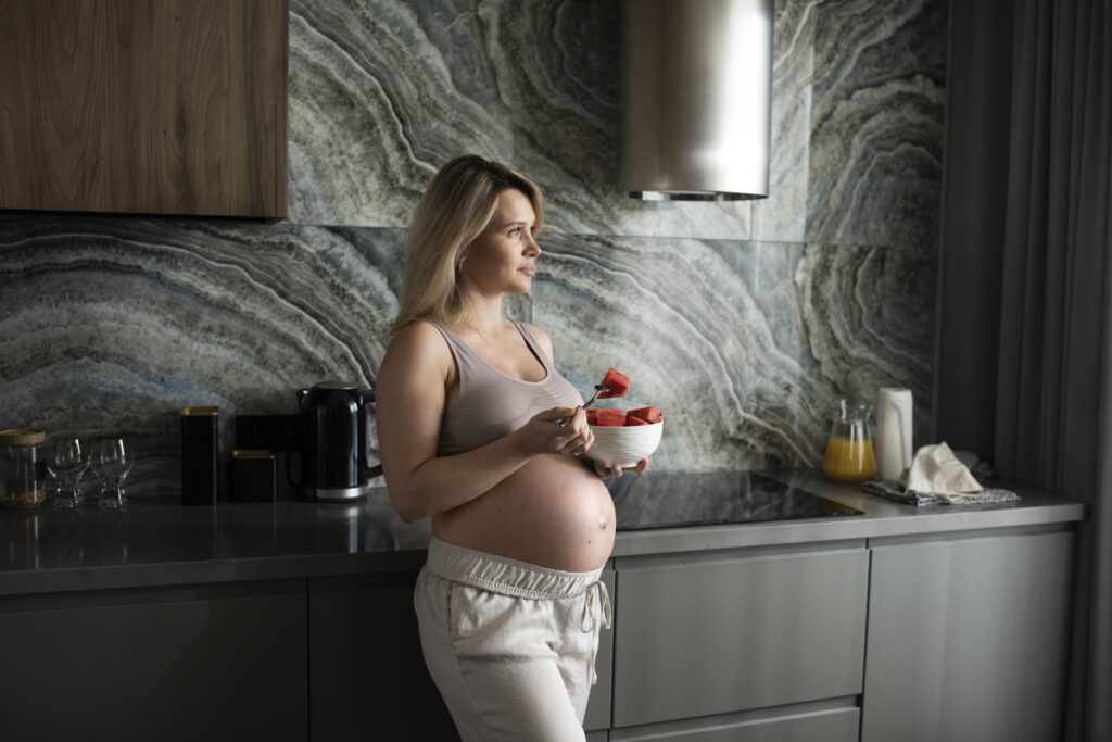 medium shot pregnant woman with fruit bowl
