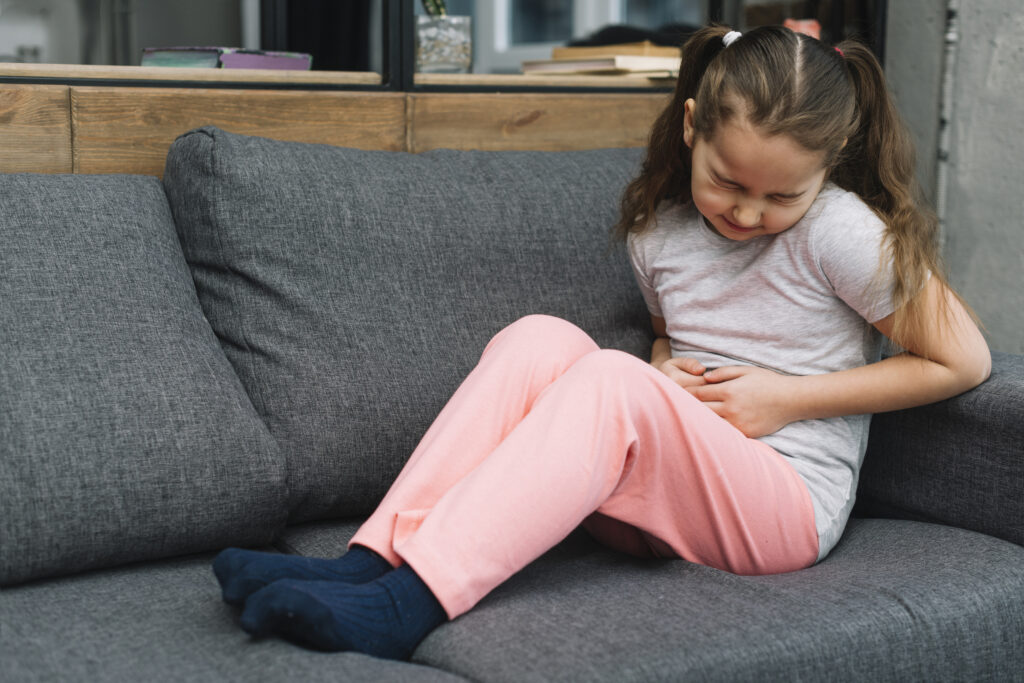 sick girl sitting gray sofa suffers from stomach pain home