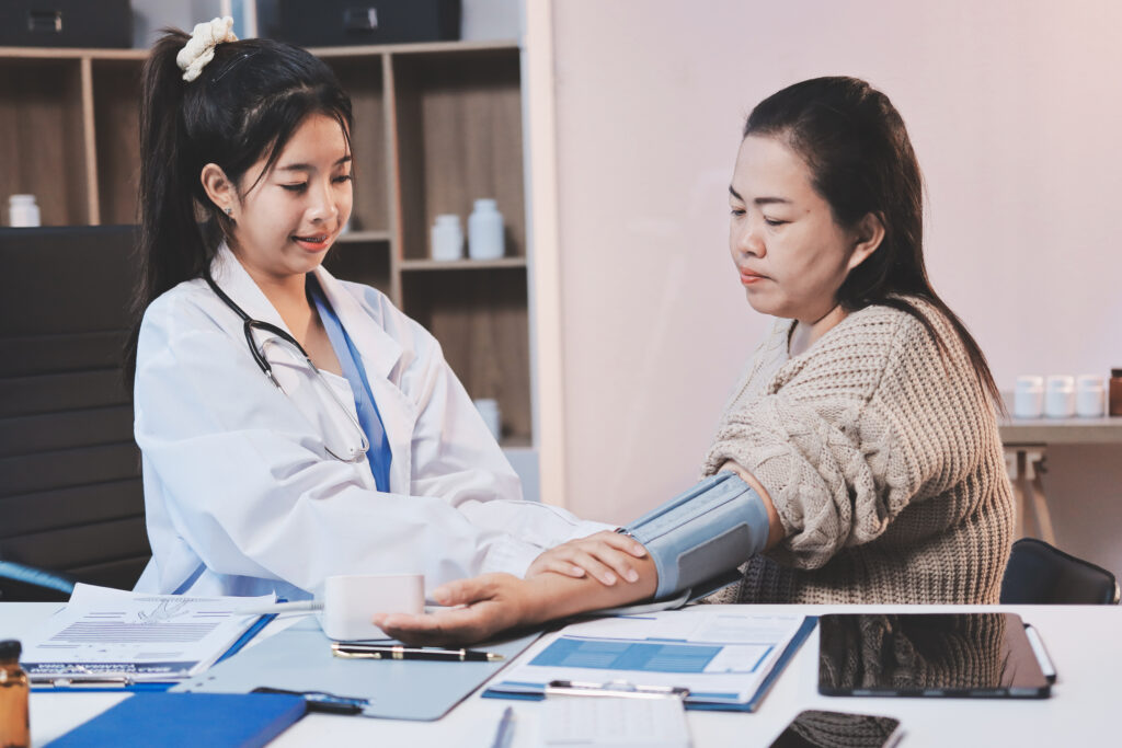 doctor using sphygmomanometer with stethoscope checking blood pr