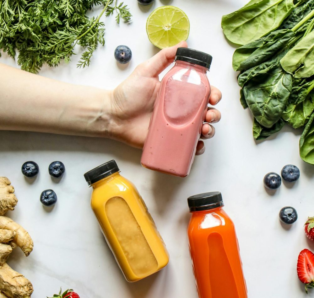 Vibrant smoothies surrounded by fresh fruits and vegetables, perfect for a healthy lifestyle.